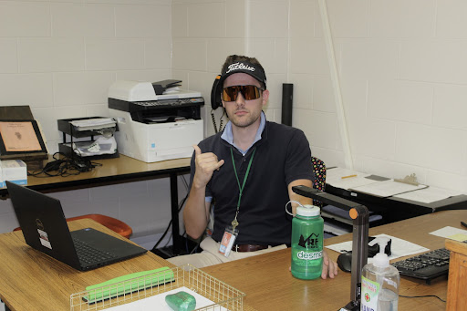 DHS teacher Steven Holt posing for a picture at his desk in his “Frat Boy Friday” outfit in his classroom at DHS on Oct. 8, 2021. Holt said he enjoyed the spirit students shown throughout spirit week. “I thought the theme was fun and enjoyed seeing all the students participating in the spirit week theme,” said Holt.
