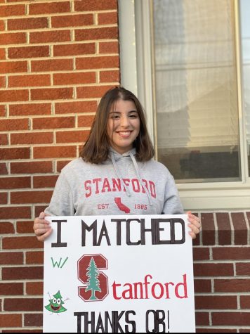 DHS Senior Zeinab Zreik holds her QuestBridge match board for Stanford. It is a QuestBridge tradition to make and take a picture with the college that you matched to. Zreik also has a matching hoodie showing her future school pride.